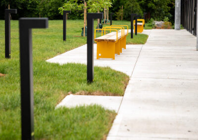 Tall black ambient lights lining the walkway to yellow player benches