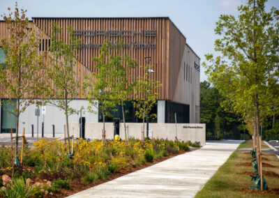 Sidewalk leading to Porsche Experience Centre Toronto with garden bed and trees