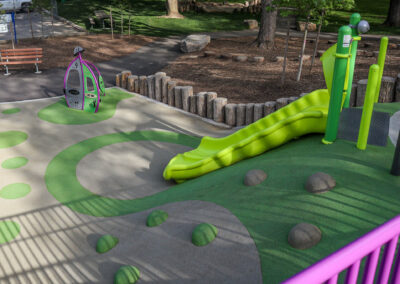 Green and purple playground with a slide and climbing rocks at Mohawk Park in Brantford