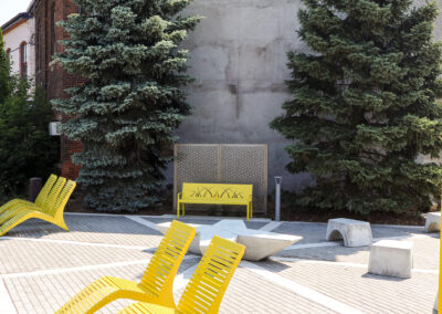 Yellow metal bench and lounge chairs at Welland Parkette