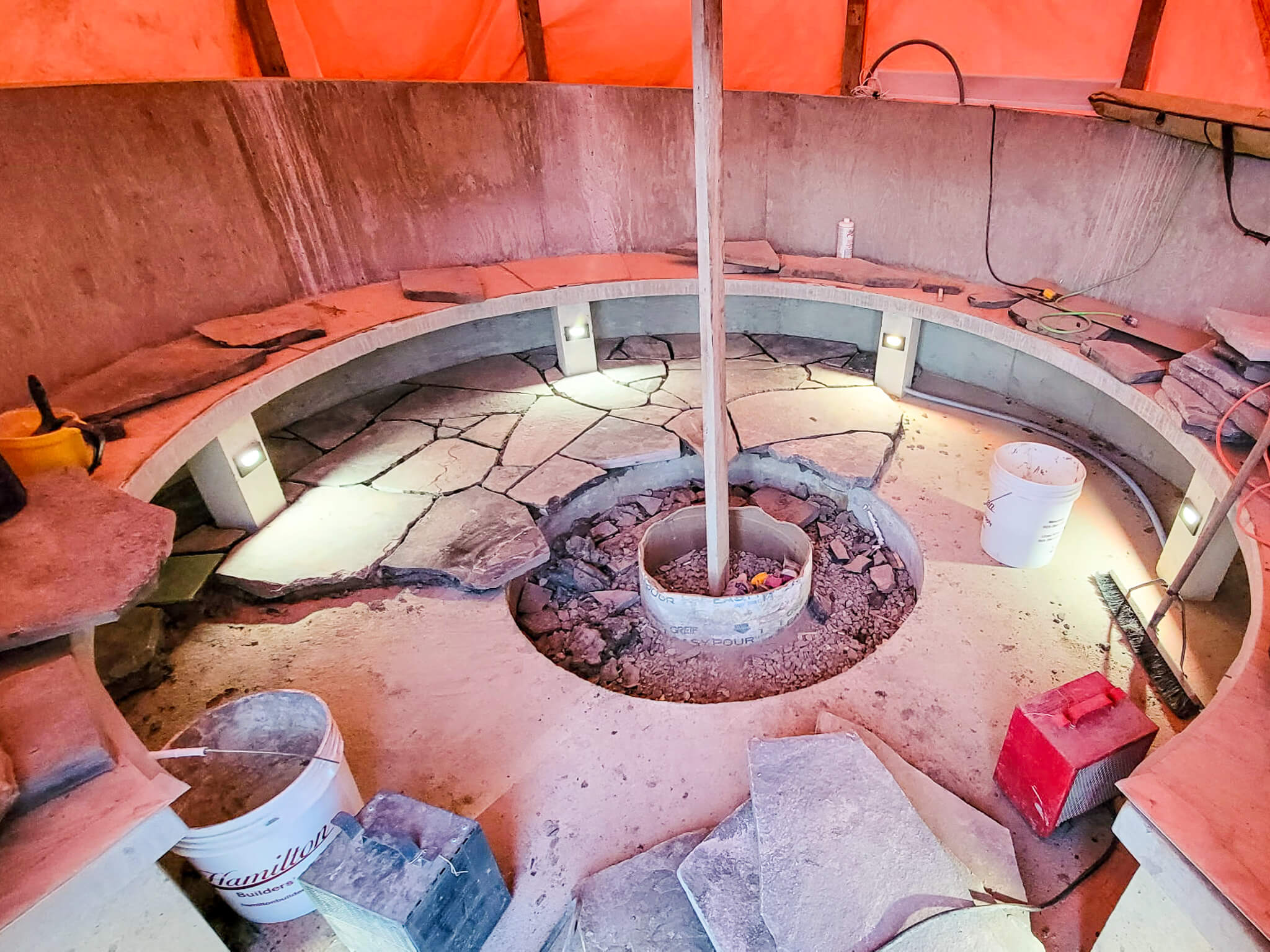 Winterized Outdoor Landscaping Fire pit construction covered with an orange tarp