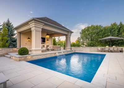 A refined backyard retreat featuring a four-season cabana, integrated water feature, and expansive stone pool deck designed for year-round enjoyment.