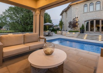 A covered cabana seating area designed for relaxed outdoor living, offering sheltered comfort, poolside views, and a seamless connection to the surrounding patio and landscape.