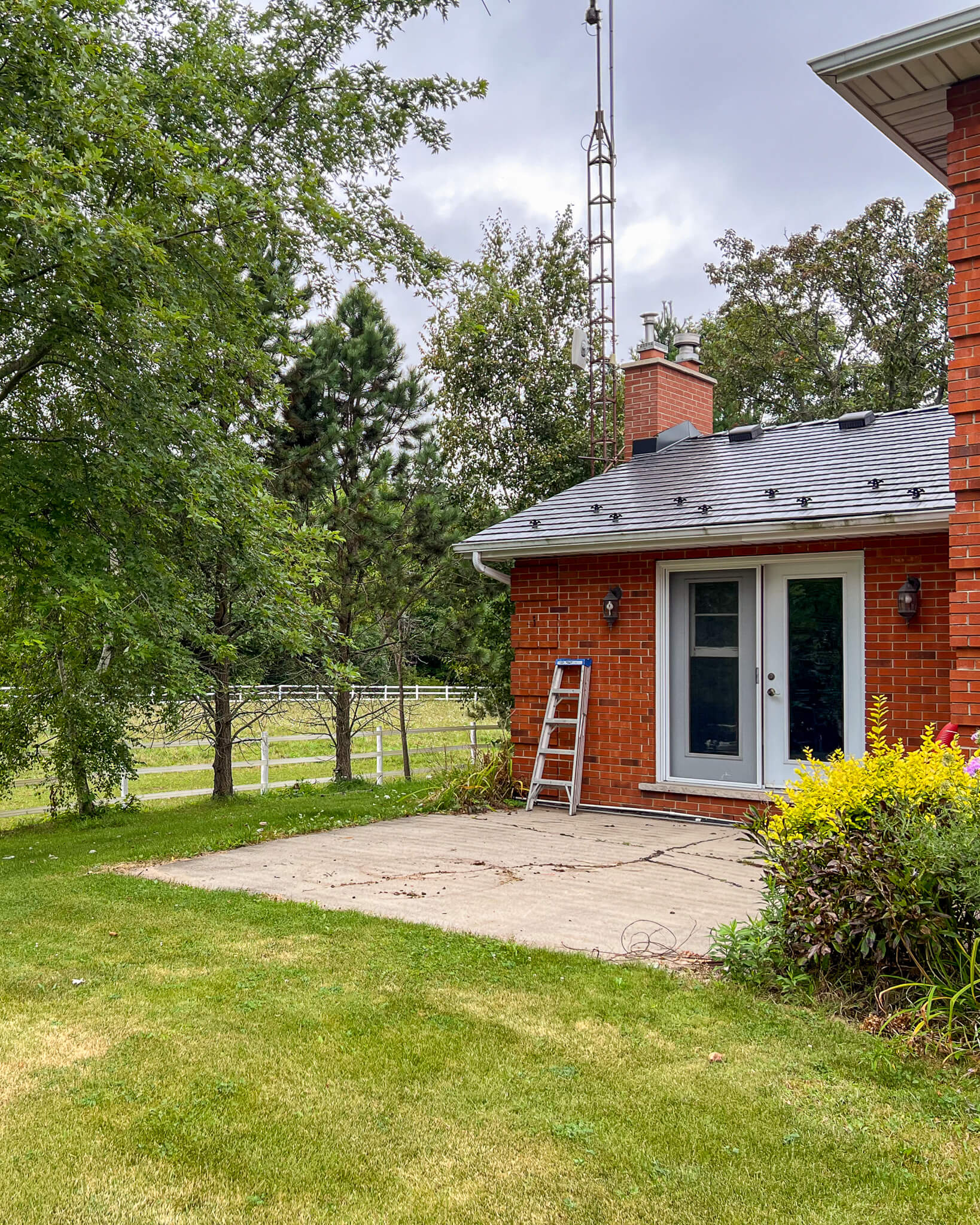 Brick country home with lawn and existing garden beds before front yard landscape redesign at Project Mountsberg.