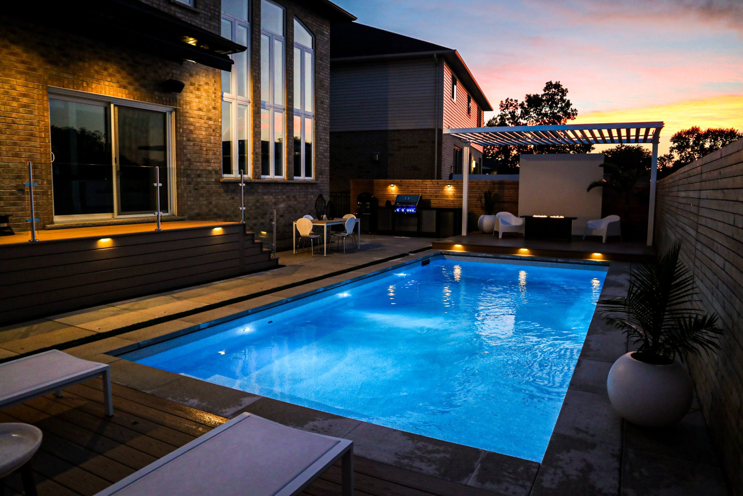 Integrated Pool and Landscape Lighting Enhancing a Modern Backyard at Dusk